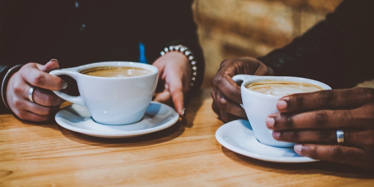 a couple drinking a cappuccino together at a table